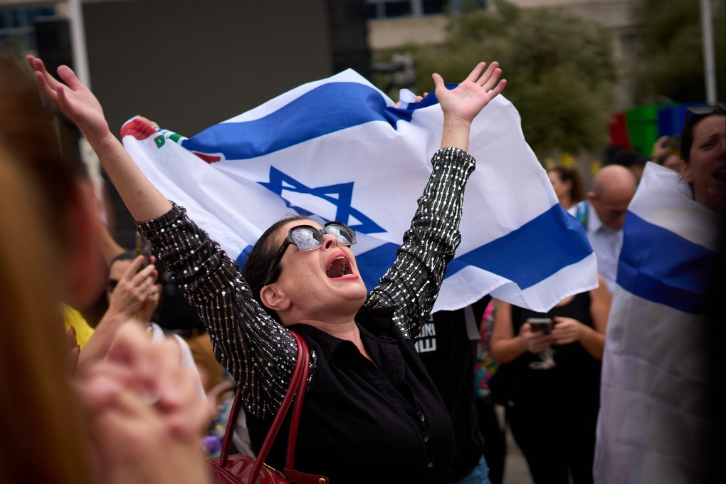 People celebrate in Tel Aviv on Thursday following the announcement that Israel and Hamas have agreed to the first phase of a peace plan . Photo: AP