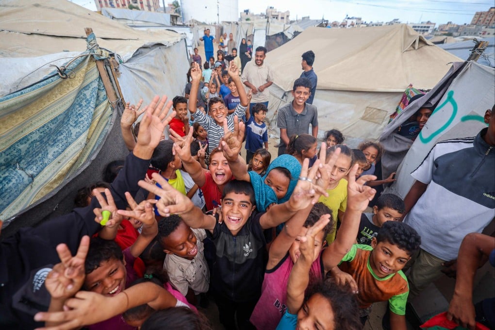 Palestinian children celebrate at a camp for displaced people in Nuseirat in the central Gaza Strip on Thursday following news of a new Gaza ceasefire deal. Photo: AFP