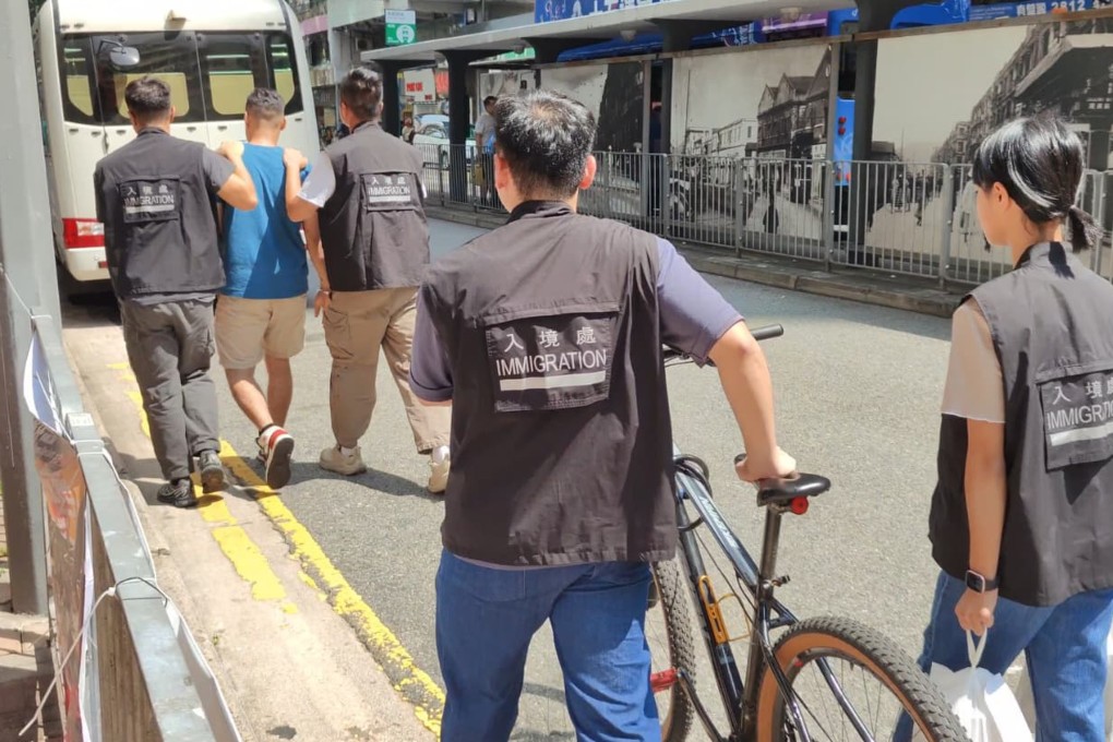 Hong Kong immigration officers detain a man suspected of working illegally as a food delivery cyclist. Photo: Handout