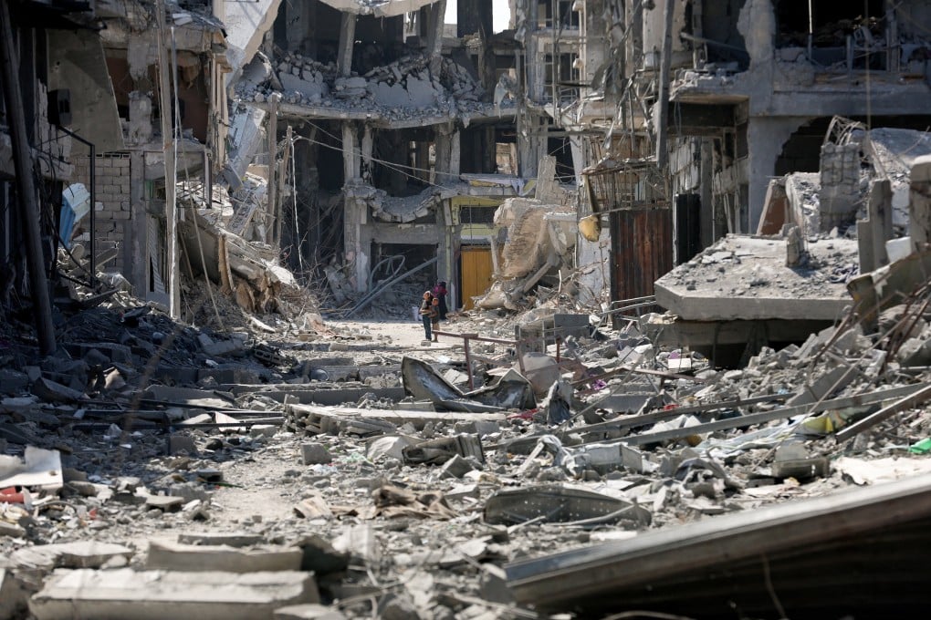 Palestinian children look at rubble following Israeli forces’ withdrawal from the area, after Israel and Hamas agreed on the Gaza ceasefire, in Khan Younis in the southern Gaza Strip on Friday. Photo: Reuters