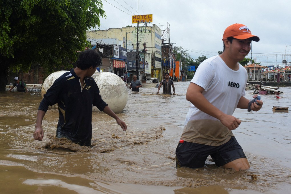 People wade through a flooded street in Poza Rica, Veracruz state, Mexico, on Friday. Photo: Reuters
