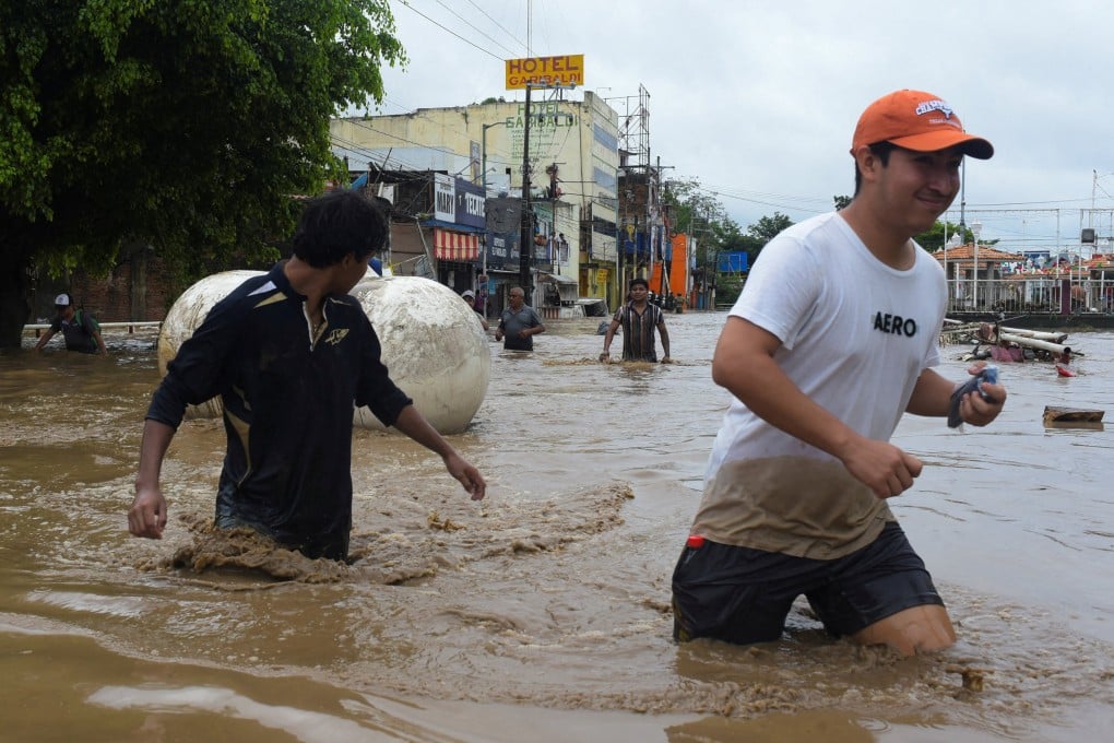 People wade through a flooded street in Poza Rica, Veracruz state, Mexico, on Friday. Photo: Reuters