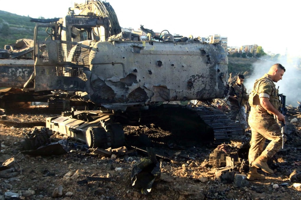 Lebanese soldiers walk next to a destroyed digger following an overnight Israeli strike on Msayleh in southern Lebanon on Sunday. Photo: AFP