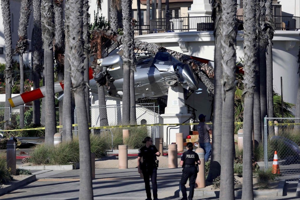 Police stand guard in front of a helicopter that crashed in Southern California on Saturday. Photo: Getty Images via AFP