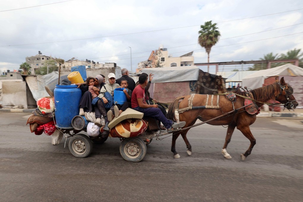 Displaced Palestinians ride a horse cart with their belongings as they pass through the Nuseirat refugee camp in central Gaza on October 12, after a ceasefire was declared. Photo: AFP