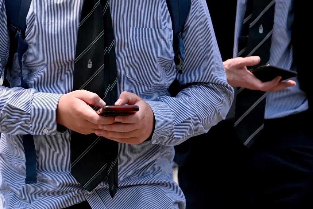 Young people look at their phones in Melbourne. Photo: AFP