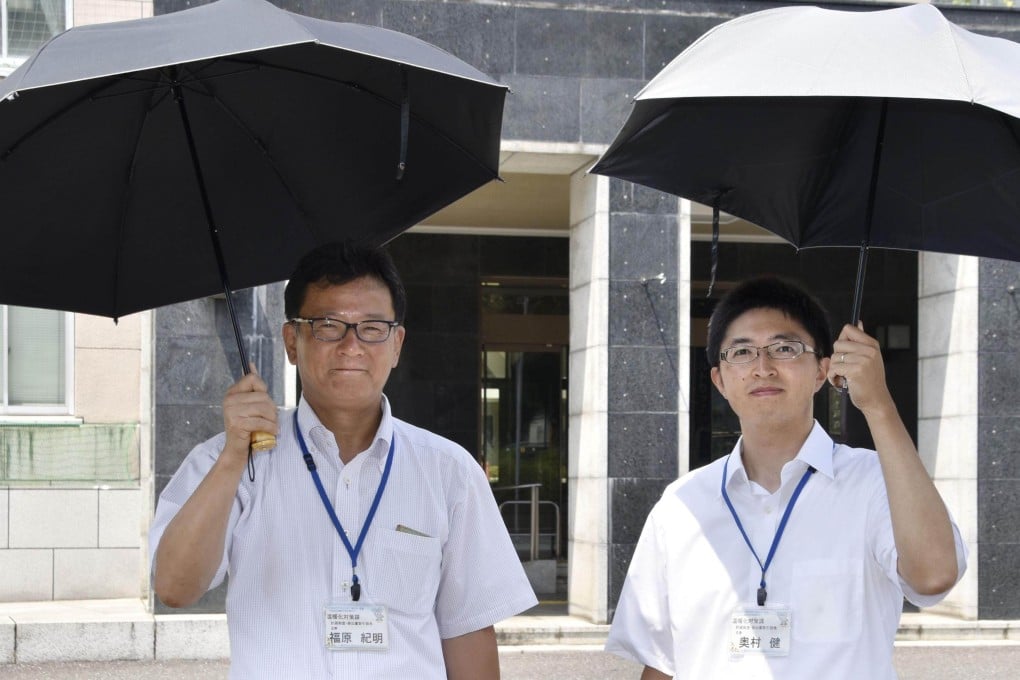 Saitama prefectural government officials promote parasols for men in Japan. Photo: Kyodo