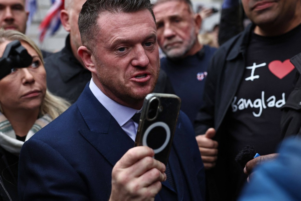 British far-right activist Tommy Robinson holds a mobile phone as he arrives at Westminster Magistrates Court in London. Photo: AFP