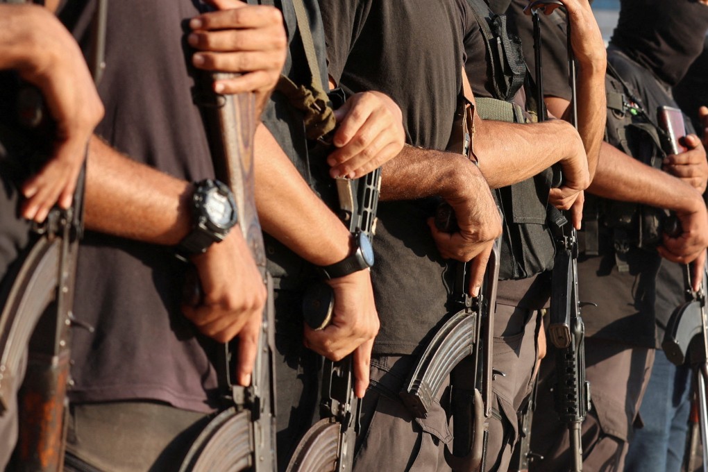 Palestinian militants stand guard as Gaza hostages are handed over on Monday. Photo: AFP