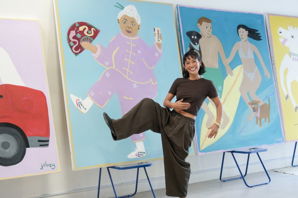 Hong Kong artist Joannah Hon poses with her paintings at her studio in Sai Ying Pun on October 7, 2025. Her art, which has gone viral on Instagram, showcases many of the city’s cultural icons. Photo: Sun Yeung