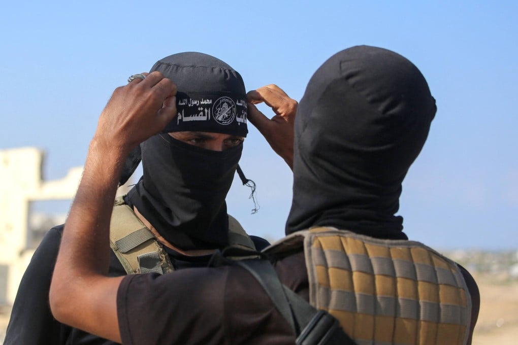 A Hamas fighter fixes the headband on his comrade’s forehead. Photo: AFP