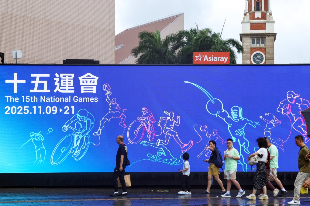 Pedestrians walk past an advertisement for the 15th National Games taking place in Guangdong province, Hong Kong and Macau. Photo: Jelly Tse