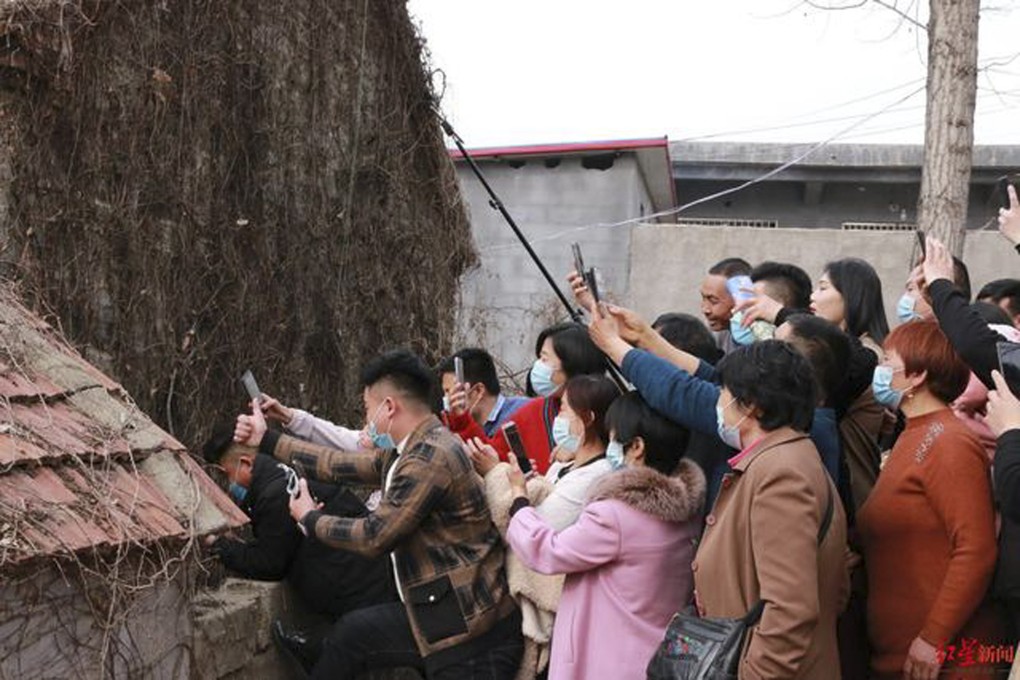People take photos of Cheng Yunfu, nicknamed “the noodle guy” by online fans, at a rural market in Feixian county, Shandong province, in 2021. Photo: Baidu