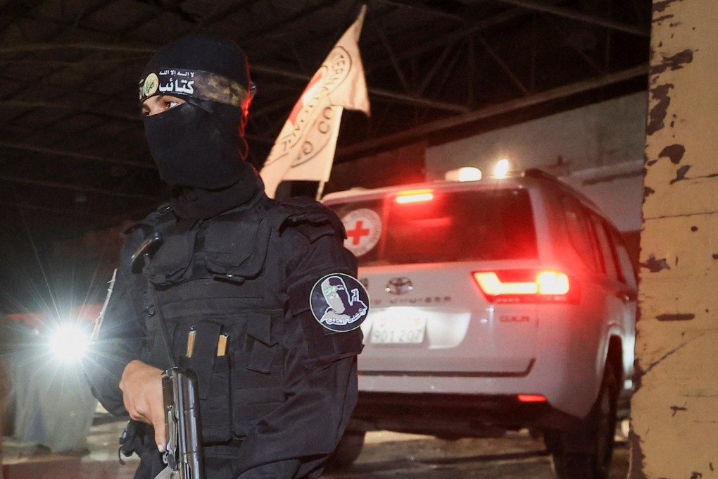 An armed Hamas militant stands guard as a Red Cross vehicle arrives to receive the bodies of deceased hostages in Gaza City on Tuesday. Photo: Reuters