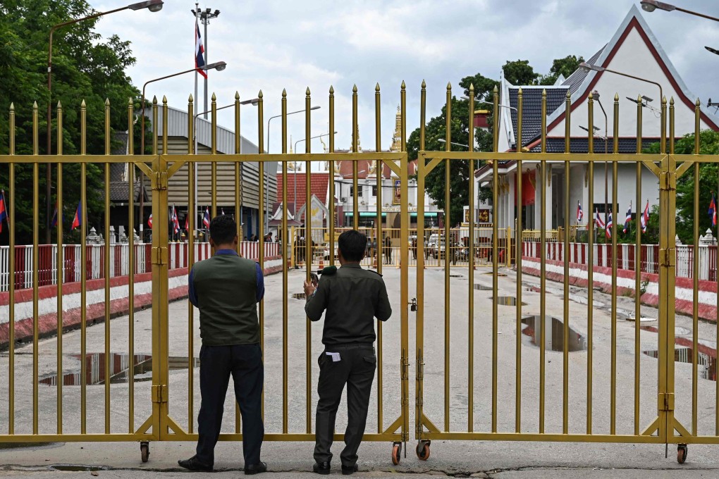 Cambodian police officials stand guard next to a closed gate at the Poipet international border checkpoint between Cambodia and Thailand. Photo: AFP