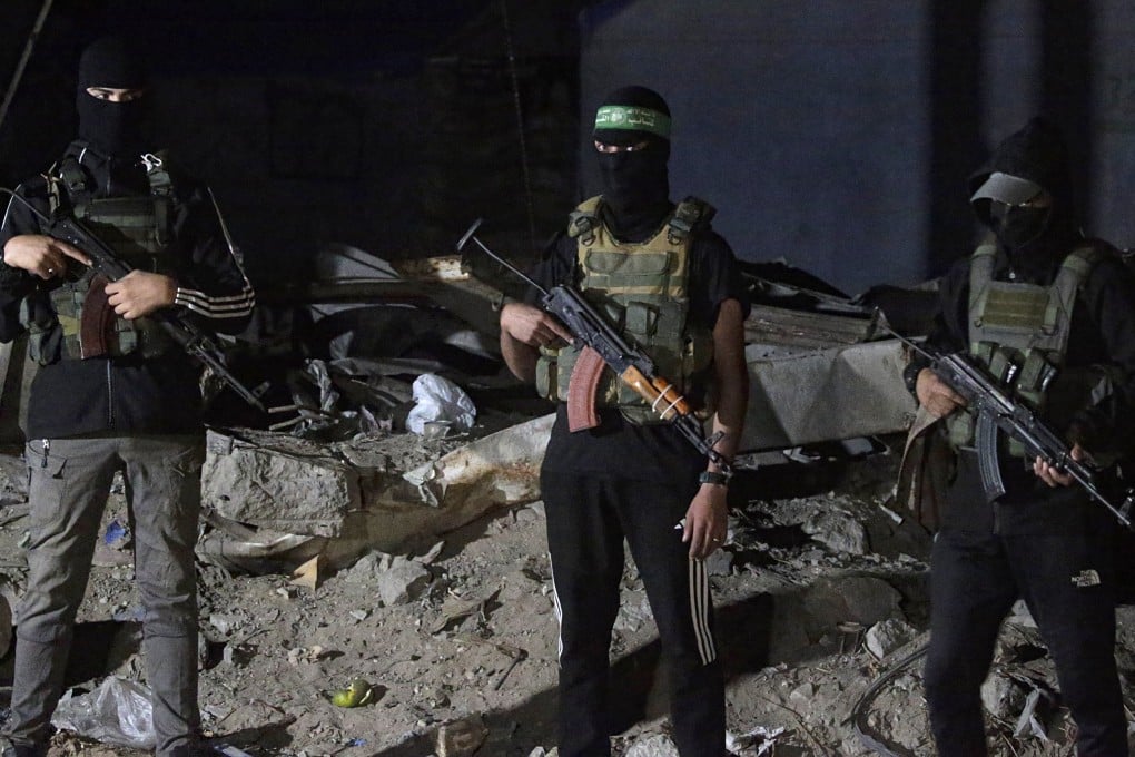 Hamas fighters stand guard as Red Cross vehicles arrive to transport remains of Israeli hostages on Wednesday. Photo: EPA
