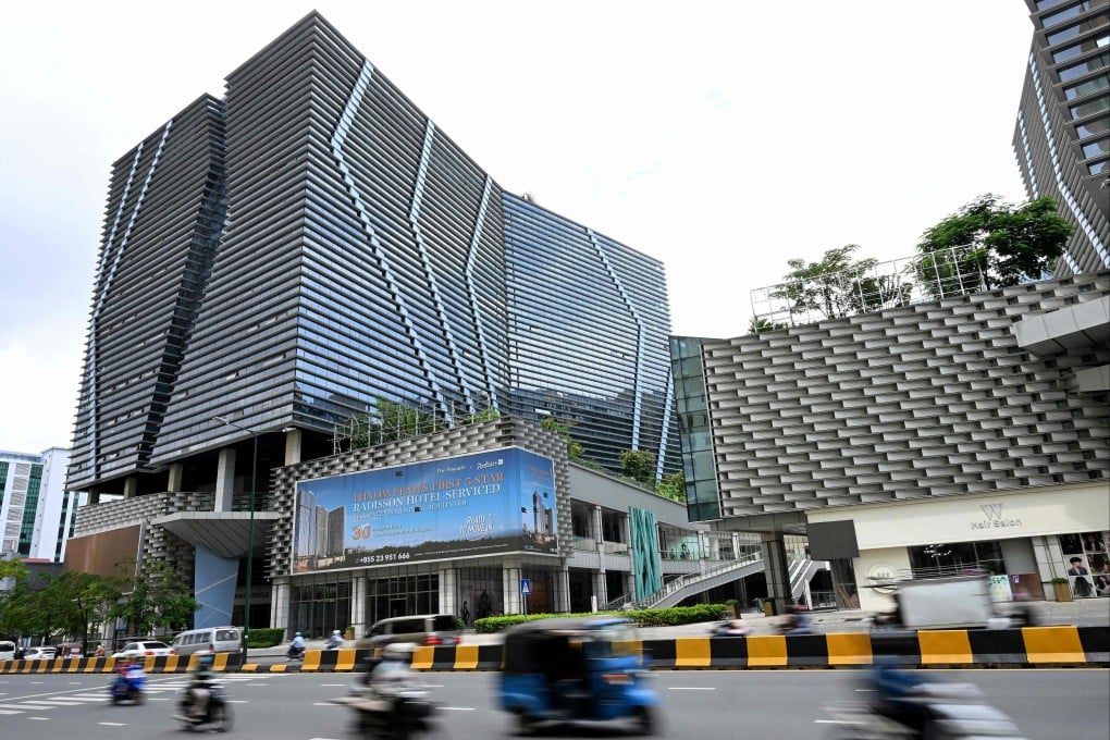Vehicles drive past the Prince International Plaza in Phnom Penh on Wednesday. Photo: AFP