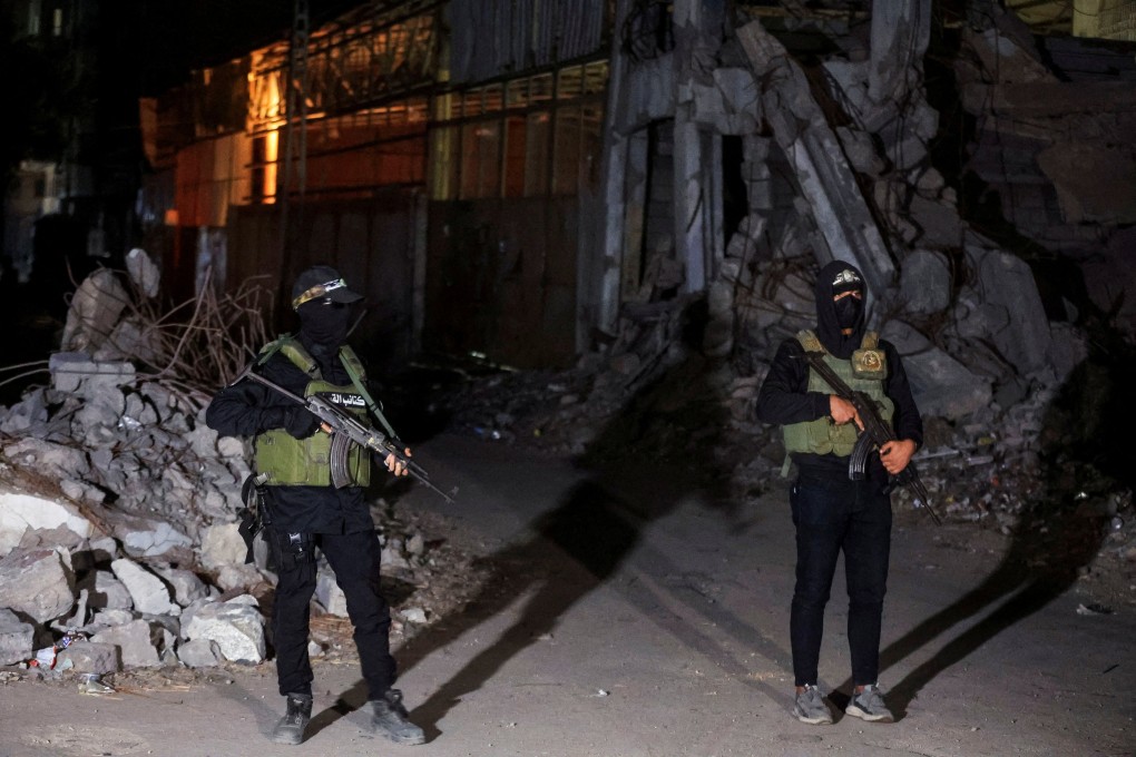 Hamas militants stand guard as Red Cross vehicles transport the bodies of hostages in Gaza City. Photo: Reuters