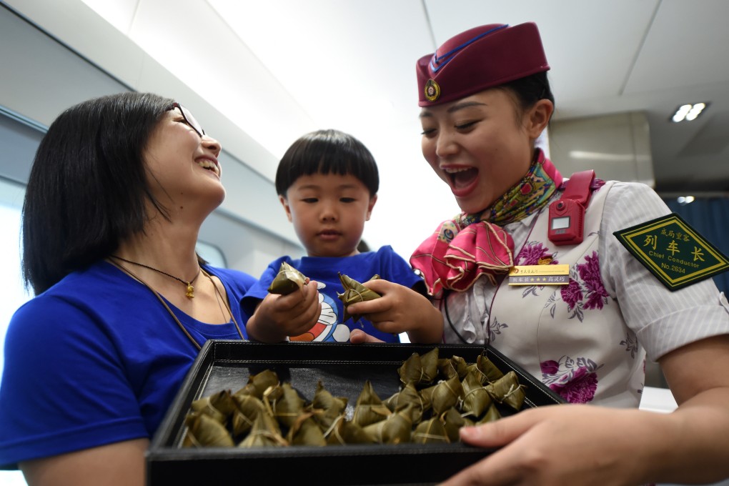 A child plays a game with zongzi, or sticky rice dumplings, on a high speed train running between Chongqing and Chengdu in southwest China in May 2017, ahead of the Dragon Boat Festival. Photo: Xinhua
