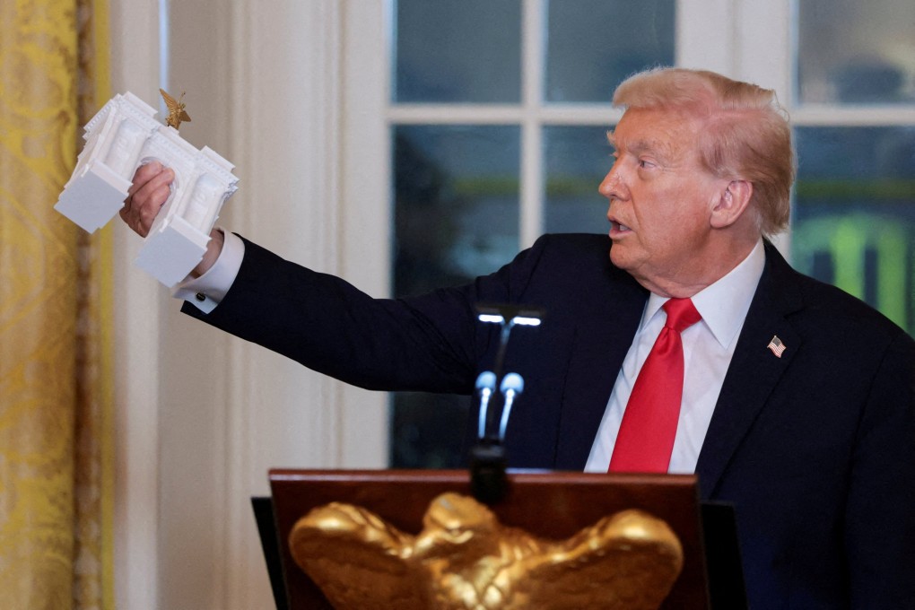 US President Donald Trump holds a model of the arch monument. Photo: Reuters