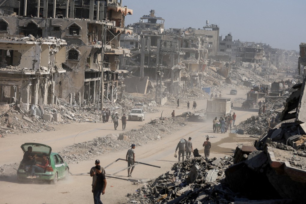 Palestinians walk past the rubble of destroyed buildings, amid a ceasefire between Israel and Hamas on Thursday. Photo: Reuters