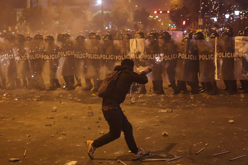 A demonstrator uses fireworks against anti-riot police in Lima on Wednesday. Photo: AFP