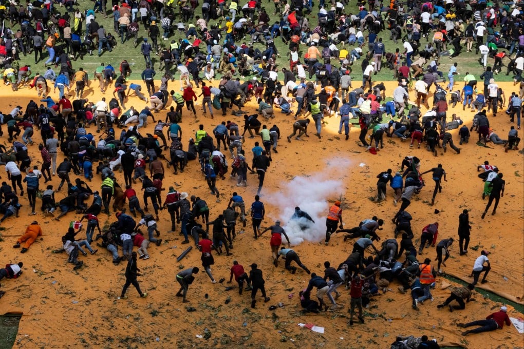 Supporters and mourners of Kenyan opposition leader Raila Odinga run for cover after gunshots and teargas were fired during a gathering for the public viewing of his coffin at the Kasarani Stadium in Nairobi on Thursday. Photo: AFP