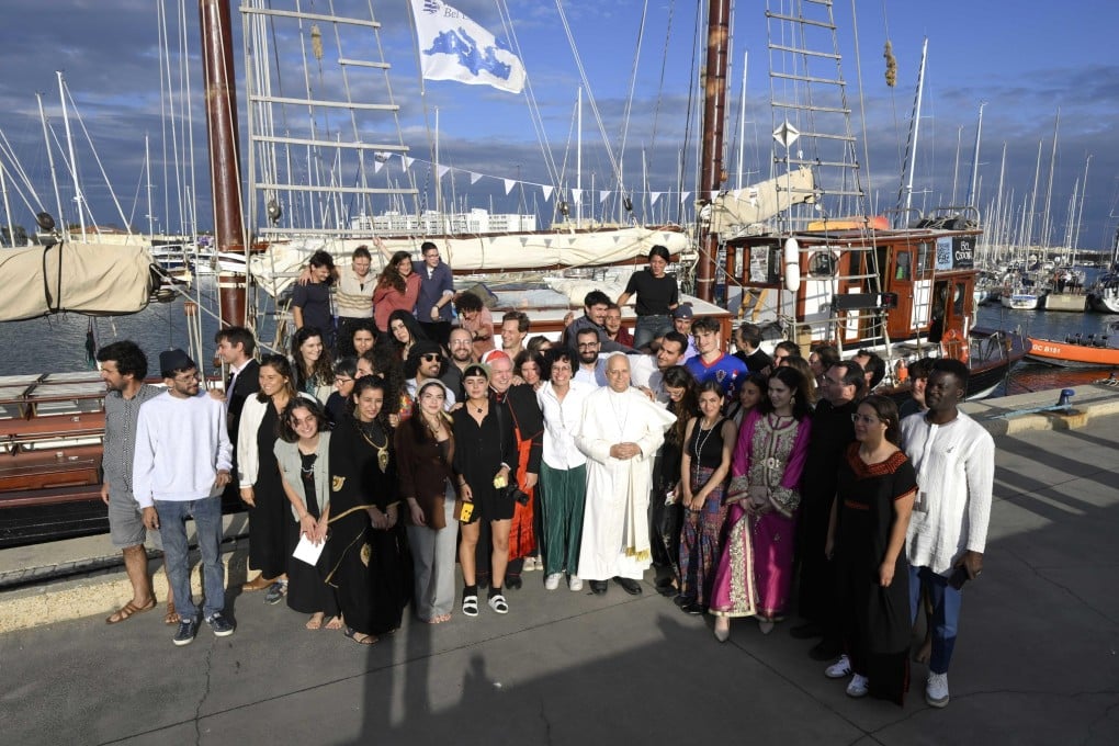 Pope Leo (centre) poses for a group photo during his visit to the Peace training ship “Med 25 – Bel Espoir”, in the port of Ostia near Rome, Italy, on Friday. Photo: EPA/Vatican Media