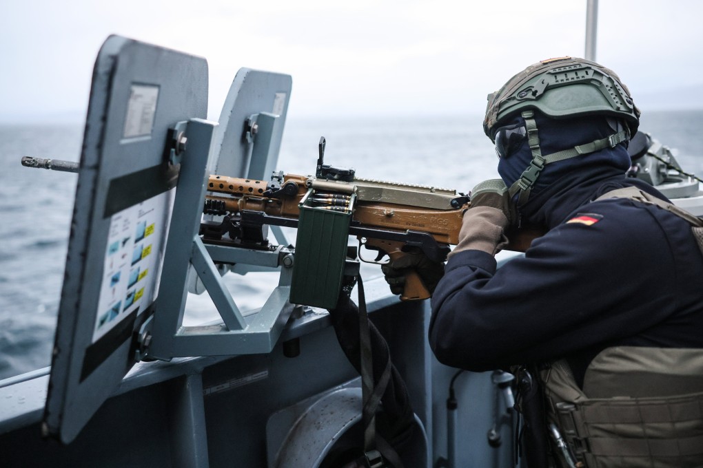 A German serviceman aims a machine gun on a naval tender near Harstad, Norway, on Thursday. Photo: EPA