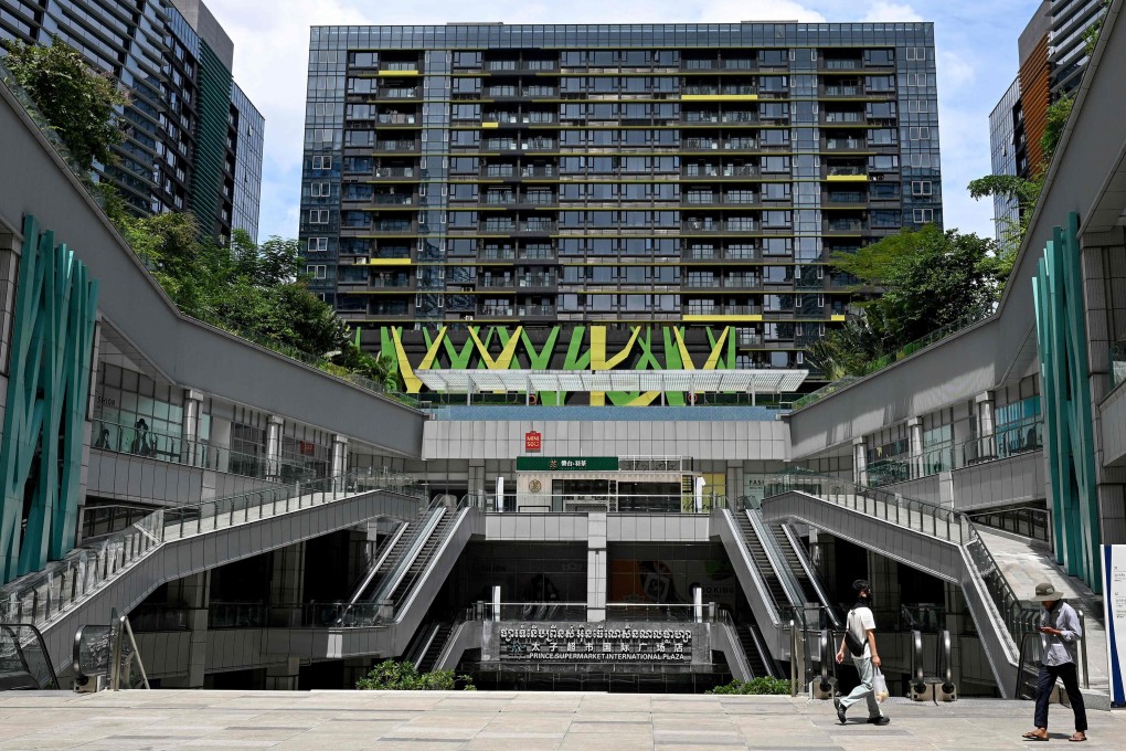 People walk past the Prince International Plaza in Phnom Penh on Wednesday. Prince Group Chairman Chen Zhi was charged on Tuesday by the US with running a “sprawling cyber fraud empire”. Photo: AFP