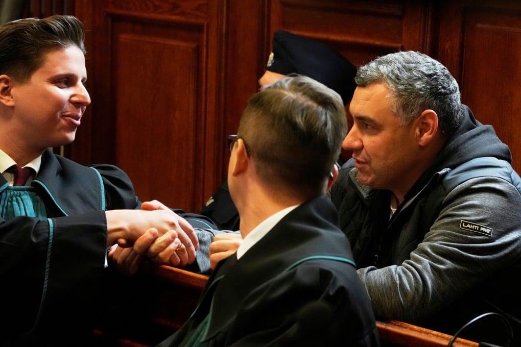 Ukrainian defendant Volodymyr Zhuravlov (right) shakes hands with his lawyer in Warsaw on Friday as a judge announces the decision not to allow for extradition to Germany. Photo: AP
