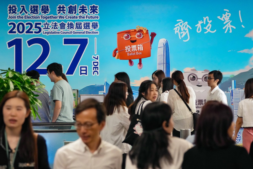 People walk past a billboard promting the Legislative Council election at the government headquarters in Admiralty on October 16. Photo: Karma Lo