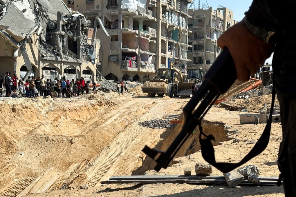 A Hamas militant stands guard in Khan Younis on Friday as a search is carried out for the bodies of hostages. Photo: Reuters