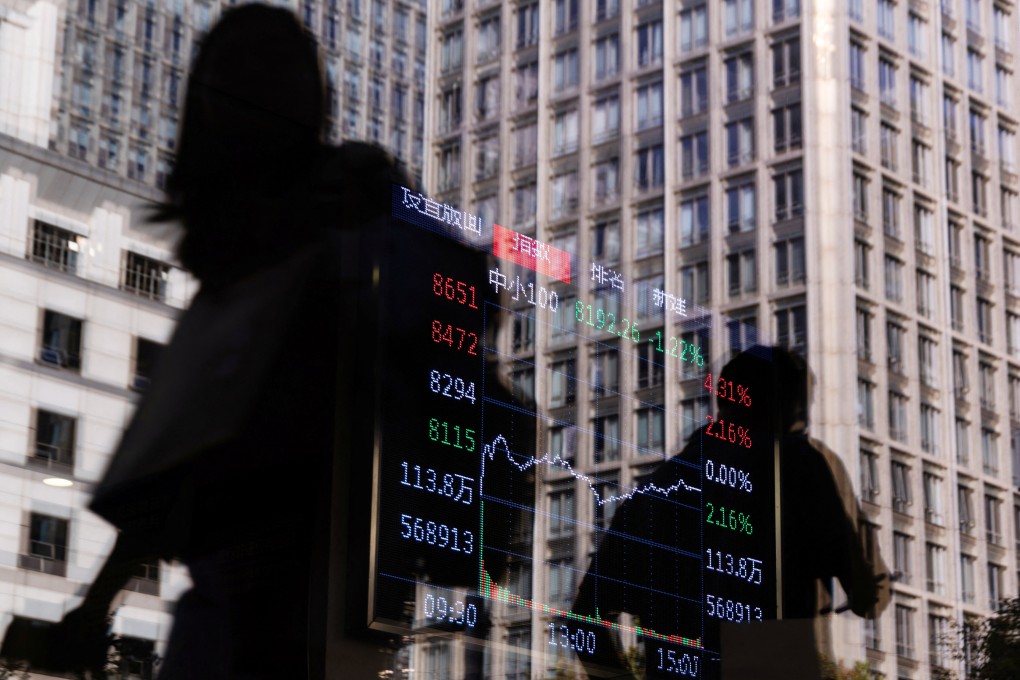 People walk past a brokerage house as an electronic board displays stock market information, in Beijing on October 13. Photo: Reuters