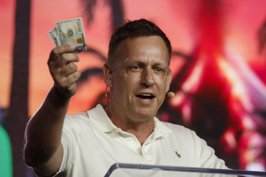 Peter Thiel, co-founder of PayPal, Palantir Technologies, and Founders Fund, holds hundred dollar bills as he speaks during the Bitcoin 2022 Conference at Miami Beach Convention Center on April 7, 2022 in Miami, Florida. Photo: Getty Images