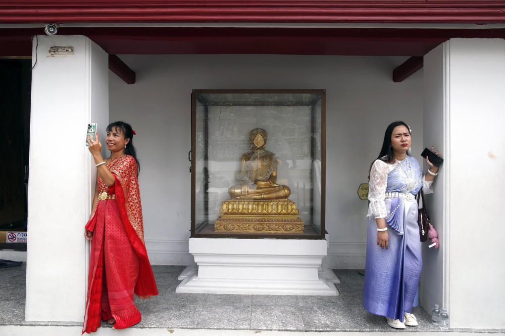Tourists dressed in Thai traditional costumes visit the Temple of Dawn or Wat Arun in Bangkok on October 6. The steep fall in Chinese tourist numbers in Thailand has been partly compensated by strength in its other source markets such as South Asia. Photo: EPA
