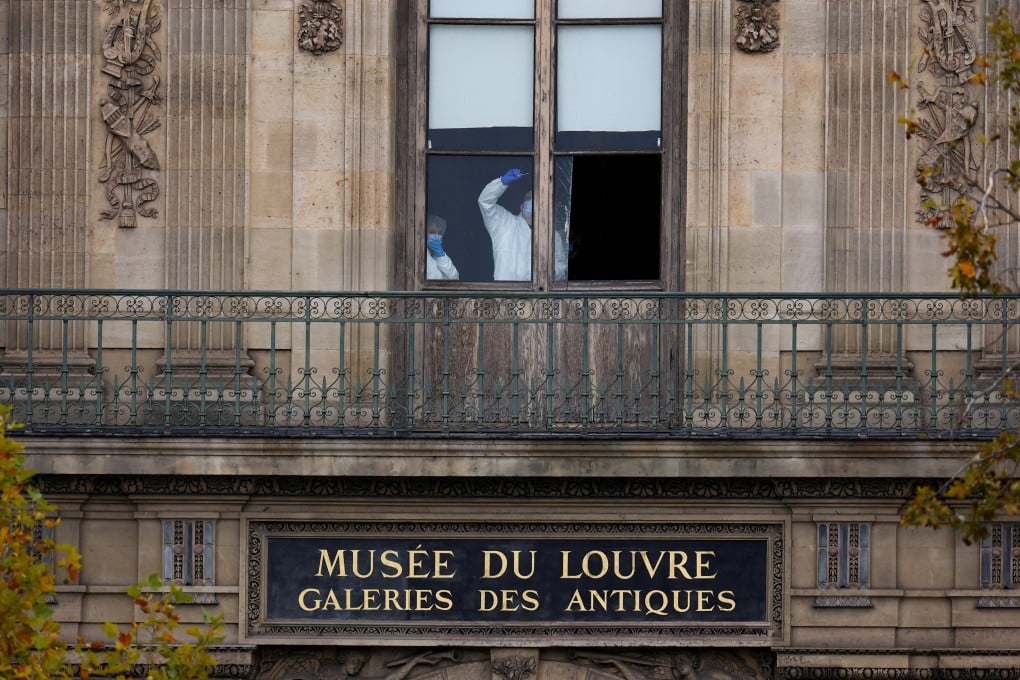 Members of a forensics team inspect a window believed to have been used in the robbery. Photo: Reuters