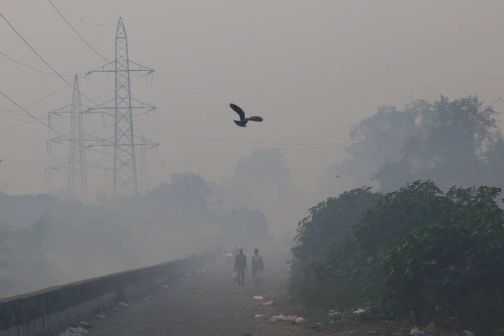 People walk through smog in New Delhi, India, on Monday morning. Photo: Reuters