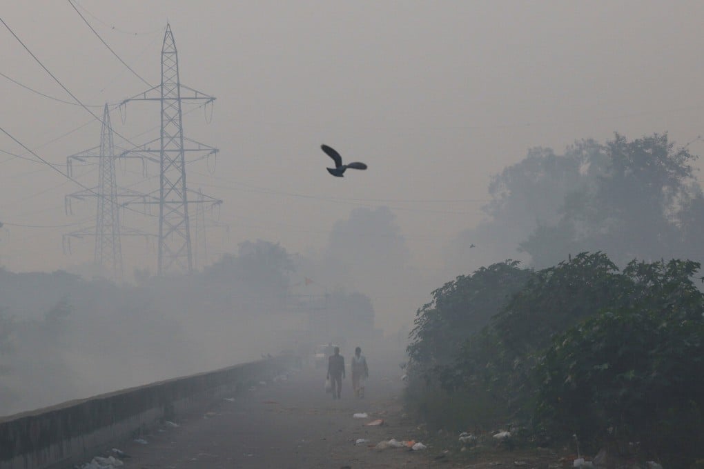 People walk through smog in New Delhi, India, on Monday morning. Photo: Reuters