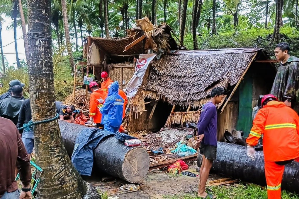 Rescuers work at the site of a house that was crushed by a fallen tree in Quezon province, the Philippines, amid strong winds brought by Tropical Storm Fengshen on Sunday. Photo: Xinhua
