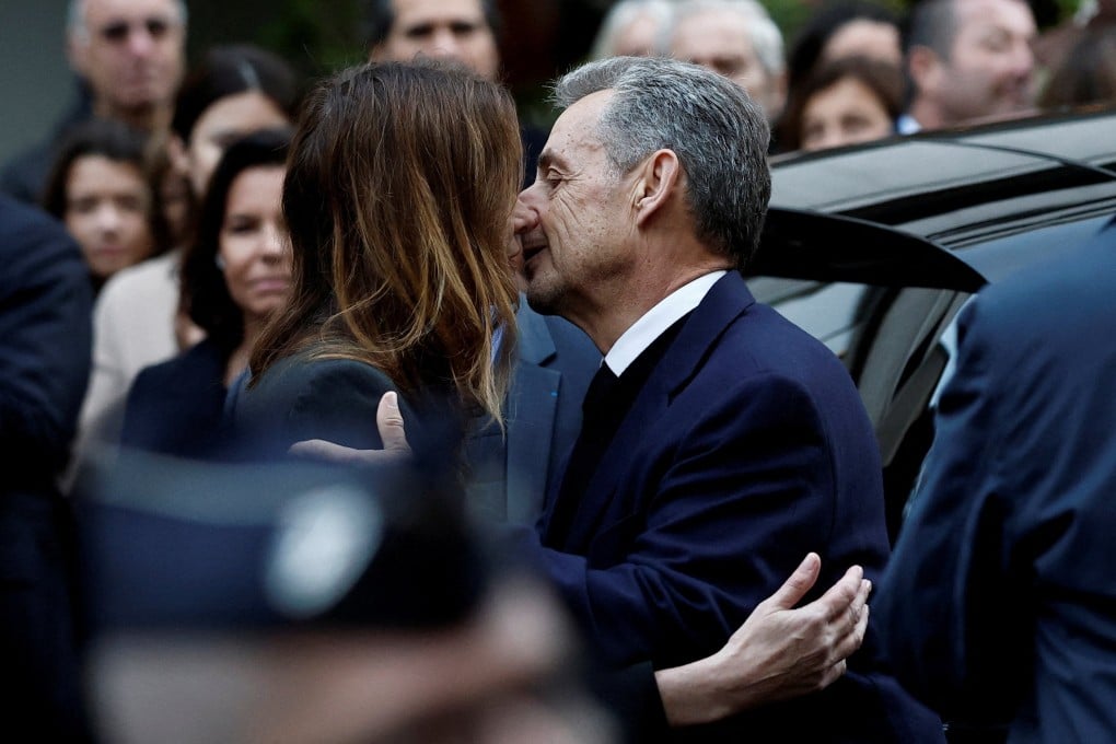 Former French President Nicolas Sarkozy kisses his wife Carla Bruni before leaving in a car to prison. Photo: Reuters