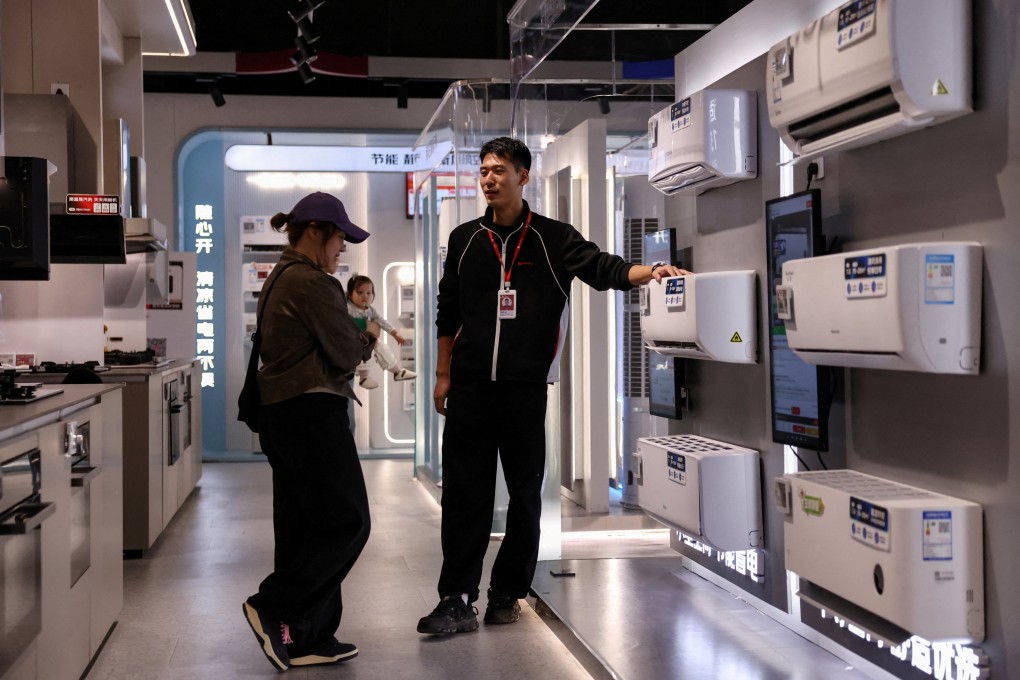 A staff member attends to a customer at a home appliance centre in Beijing on October 19. Diverting government resources to social spending would improve the confidence of Chinese people to spend more of their hard-earned income. Photo: Reuters