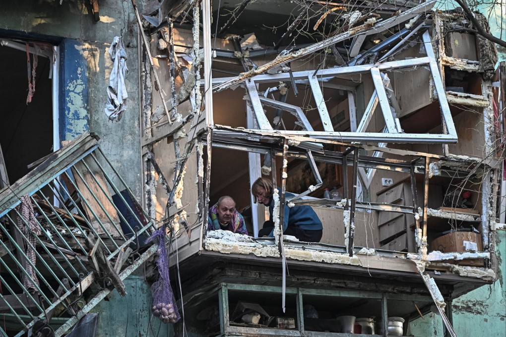 Residents in Zaporizhzhia, Ukraine clean the balcony of their flat after their building was hit in a Russian drone strike. Photo: Reuters