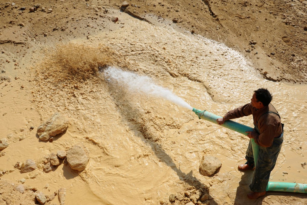 A worker waters the site of a rare earth metals mine at Nancheng county in Jiangxi province in January 2011. Photo: Reuters