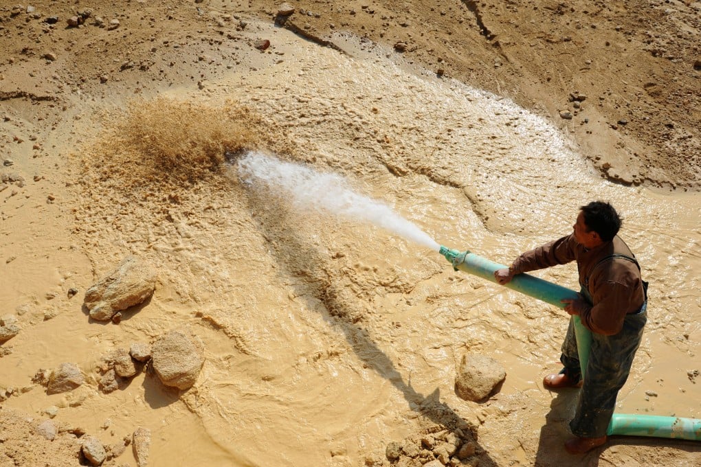 A worker waters the site of a rare earth metals mine at Nancheng county in Jiangxi province in January 2011. Photo: Reuters