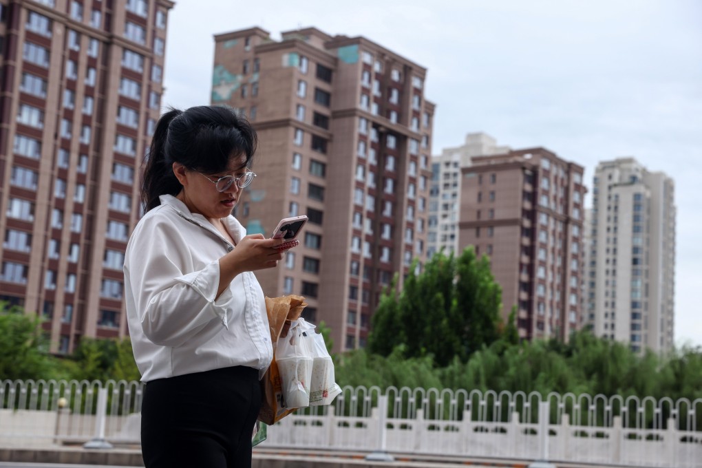 A person checks their phone outside a residential community in Beijing, on September 15. Photo: EPA