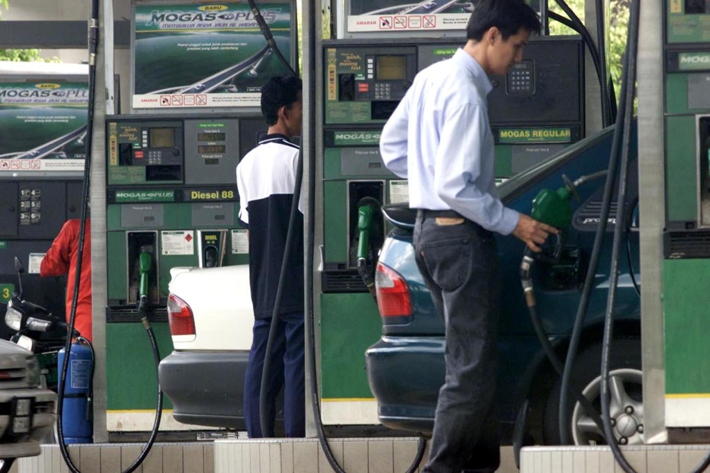 Malaysian drivers pump petrol into their vehicles at a filling station in Kuala Lumpur in 2000. Photo: Reuters