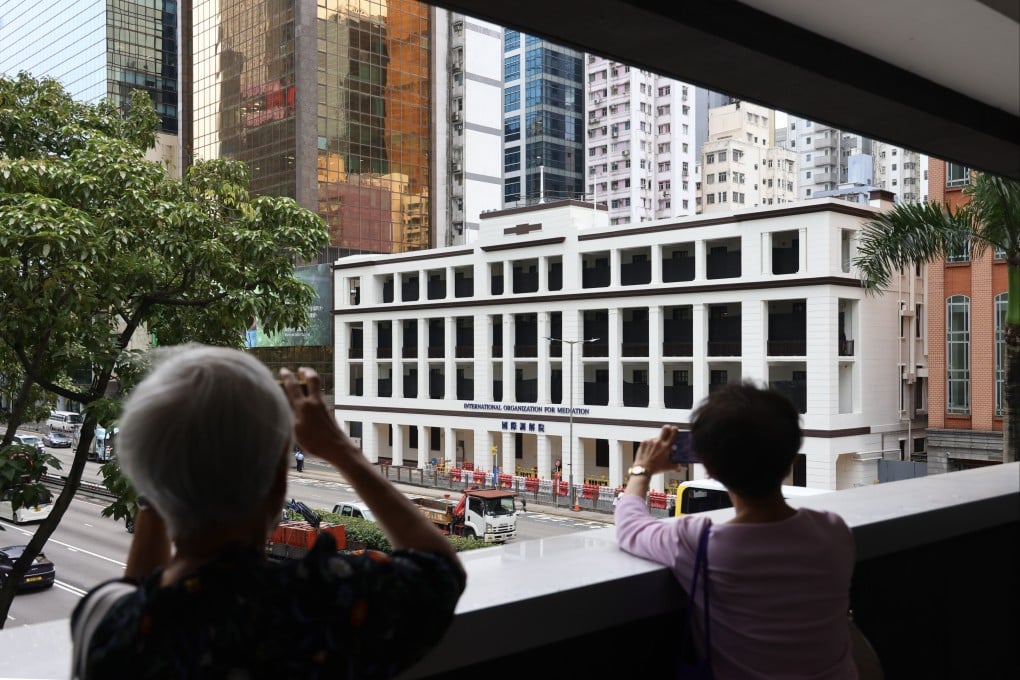 Pedestrians take pictures of the International Organisation for Mediation’s Hong Kong headquarters, in Wan Chai, on May 30. Photo: Dickson Lee