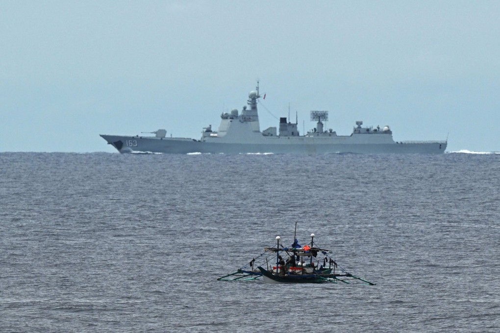 A Chinese navy ship speeds past a Philippine fishing boat in the disputed South China Sea last month. Photo: AFP