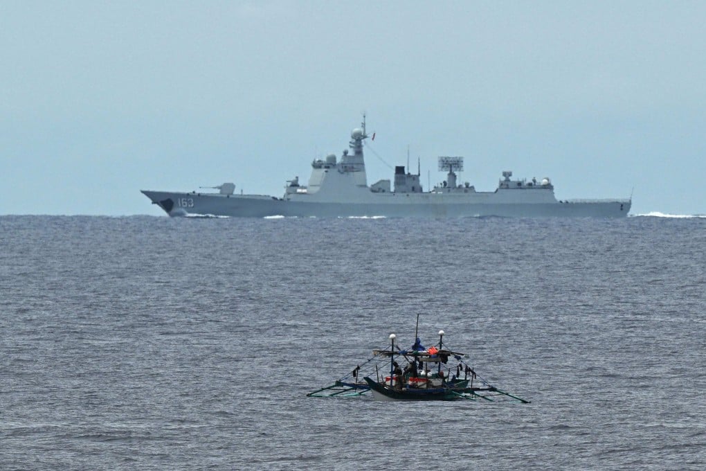 A Chinese navy ship speeds past a Philippine fishing boat in the disputed South China Sea last month. Photo: AFP